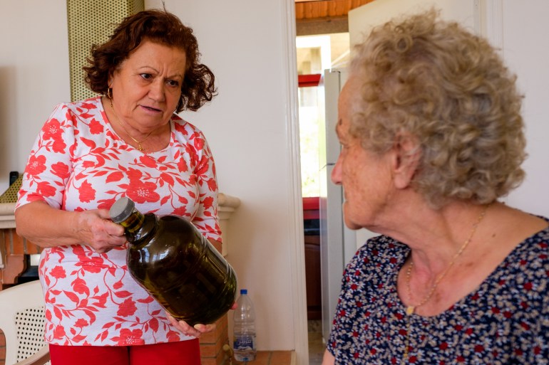 Salma showing Amaline a bottle of olive oil