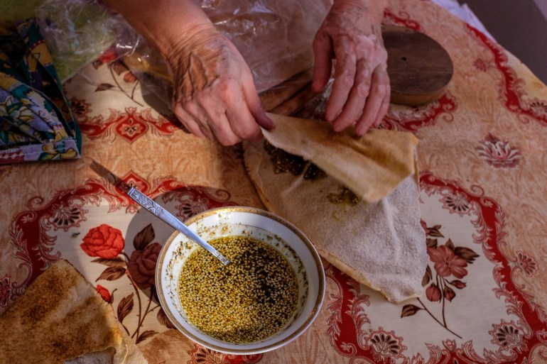 Salma's hands as she makes a zaatar sandwich with her homemade zaatar and homemade olive oil at her home in Mazraat el-Toufah