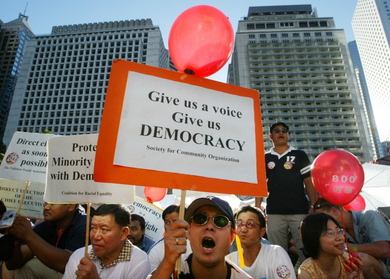 Protestocular, 13 Temmuz 2003'te Hong Kong'daki bir miting sırasında siyasi reform çağrısında bulundular.