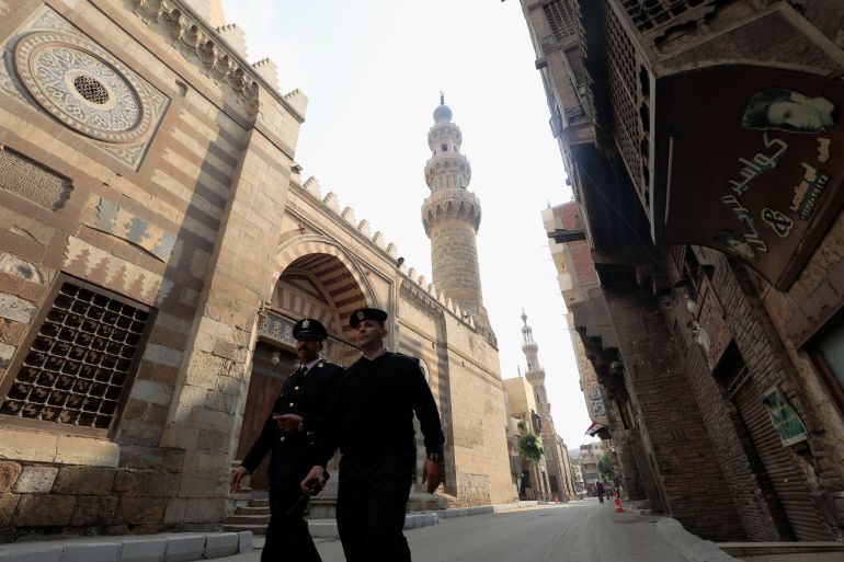 Egyptian police officers walk by Jama'a Al-Aqsunqur, Blue Mosque, during a visit of Britain's Prince Charles in Cairo, Egypt