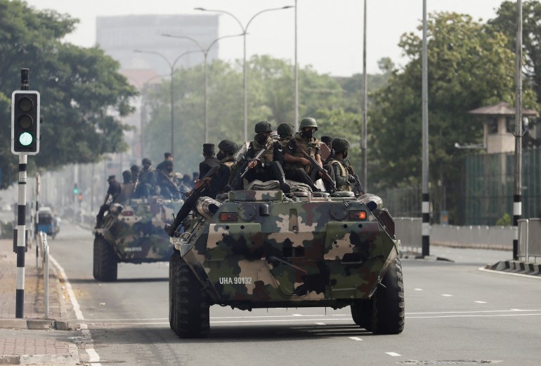 Army members travel on armoured cars on the main road during a curfew in Colombo, Sri Lanka