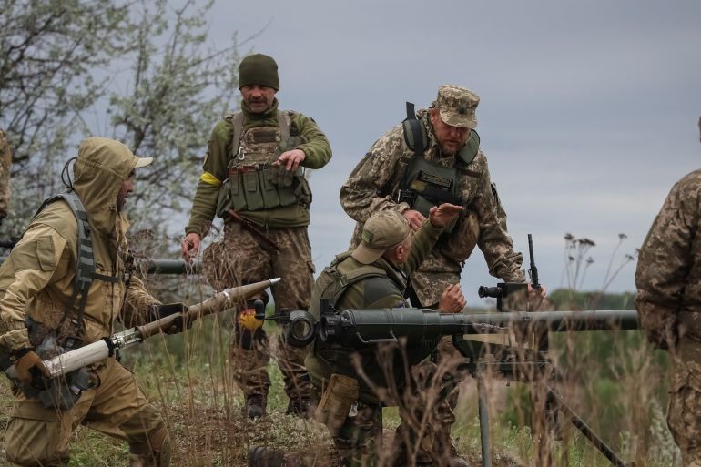 Ukrainian servicemen of the Territorial Defence Forces use an anti-tank grenade launcher