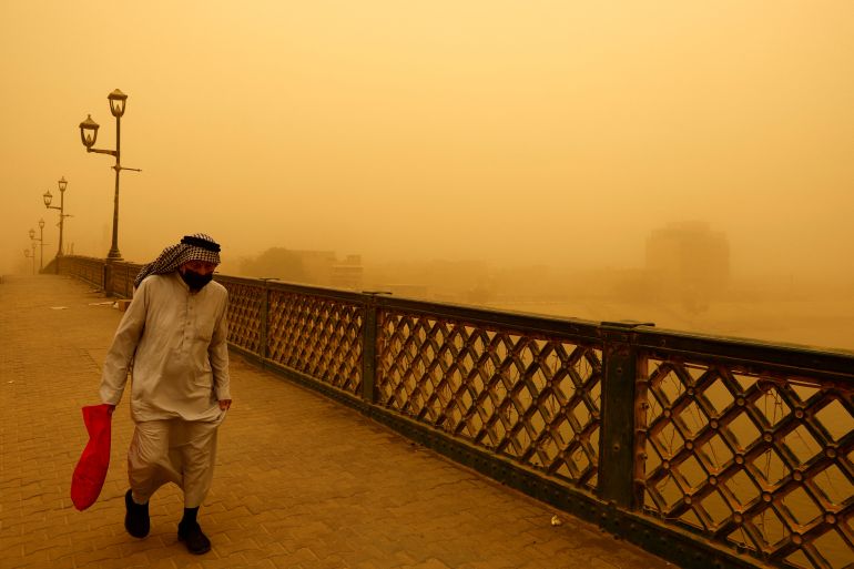 A man walks on a bridge during a sandstorm in Baghdad, Iraq.