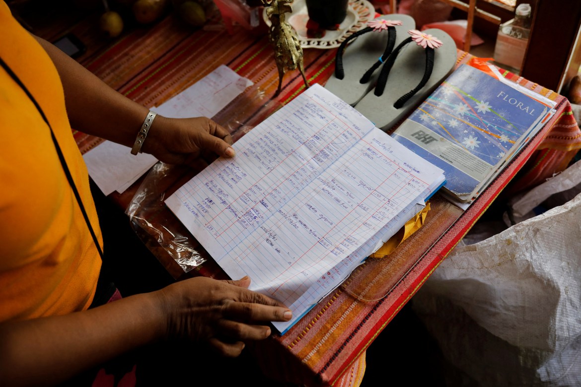 Lasanda Deepthi, 43, an auto-rickshaw driver for local ride hailing app PickMe, goes through her log book of expenses at home in Gonapola town