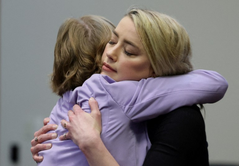 Amber Heard hugs her lawyer after the jury announced its decision in Virginia