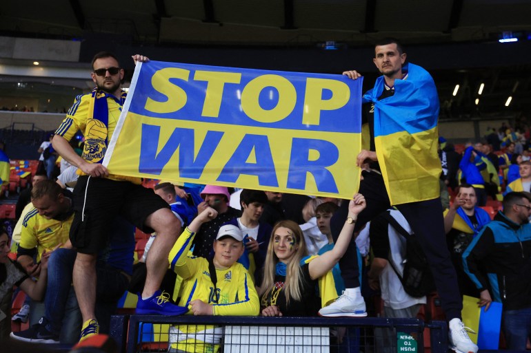 Mavi ve sarı Ukraynalı futbol taraftarları, Ukrayna'nın İskoçya'ya karşı Dünya Kupası zaferini kutluyor