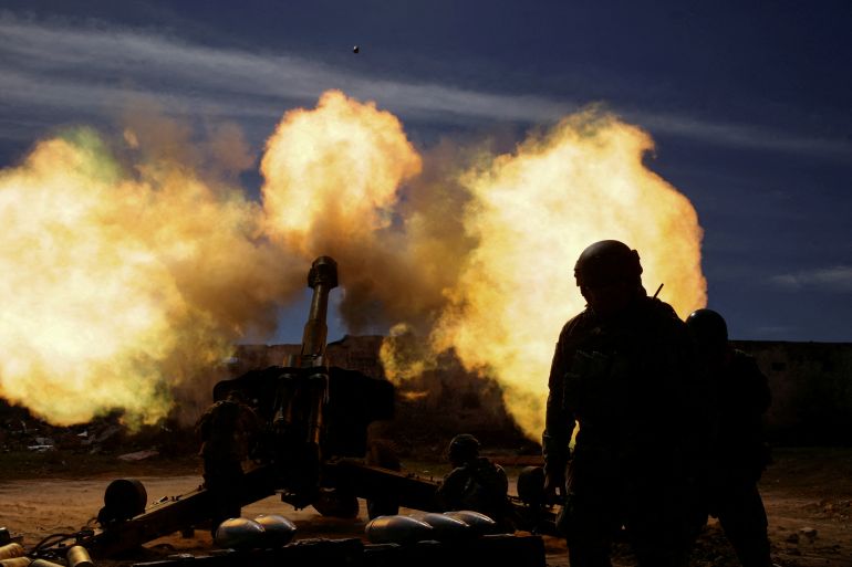 Members of the Ukrainian Volunteer Corps are seen firing with a howitzer