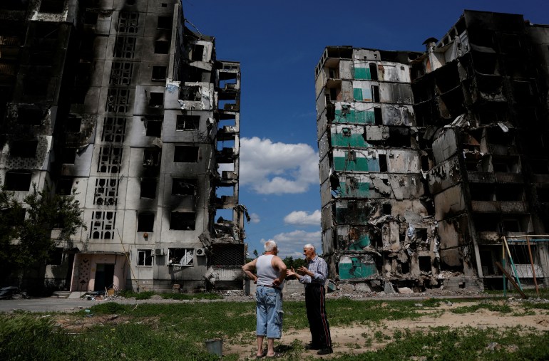 Residents chat in front of a destroyed building in Borodianka, as Russia's attacks on Ukraine continue, Kyiv Region, Ukraine June 4, 2022. 