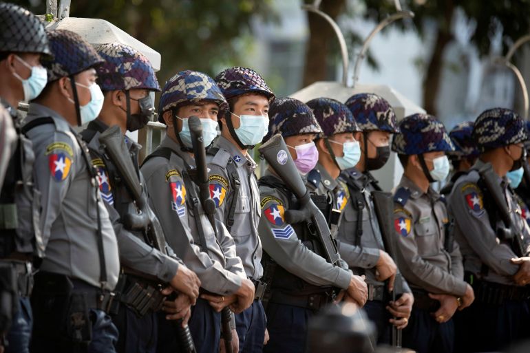 Myanmar police standing in a line waiting to confront anti-coup protesters