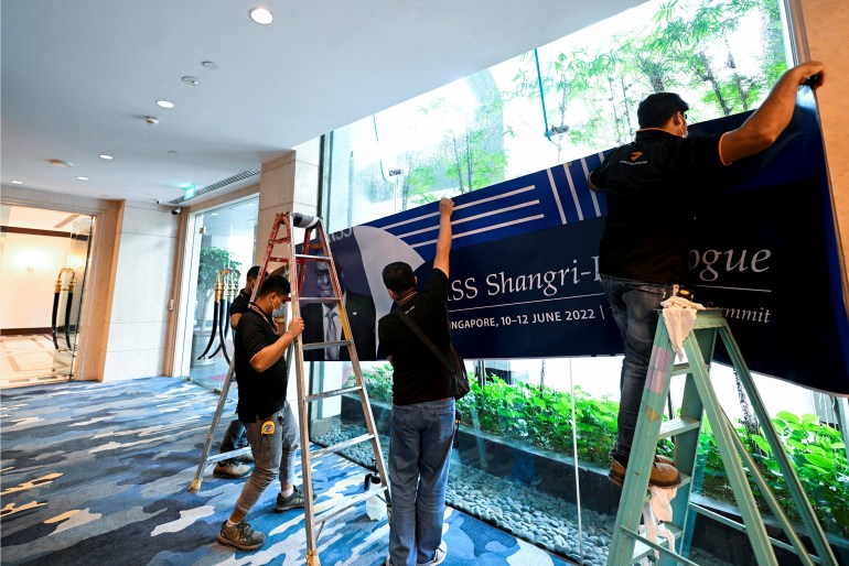 Perşembe günü Singapur'da Shangri-La diyaloğu için pankartlar asan işçiler