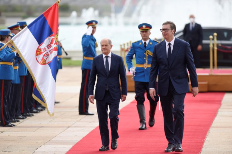 German Chancellor Olaf Scholz receives an honour guard, while walking with Serbian President Aleksandar Vucic, in Belgrade, Serbia