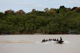 Brazilian soldiers sit in a boat during the search for Dom Phillips and Bruno Pereira