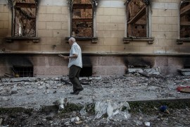 A man walks next to a building damaged by a military attack in Luhansk, Ukraine.