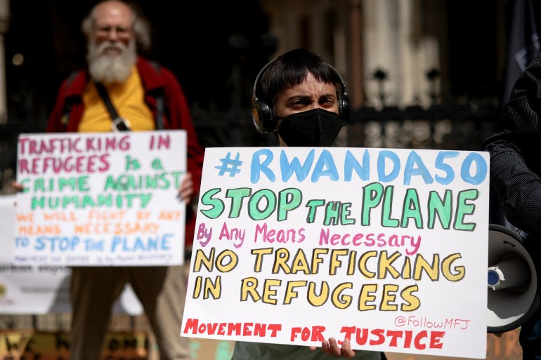 Demonstrators display placards during a protest outside the Royal Courts of Justice whilst a legal case is heard over halting a planned deportation of asylum seekers from Britain to Rwanda