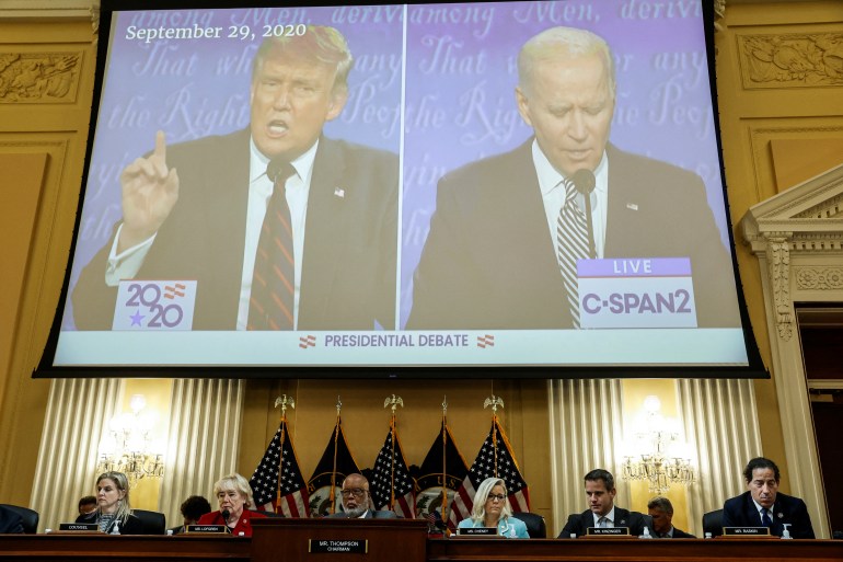 Videos of Trump and Biden side by side on large screen at the committee hearing
