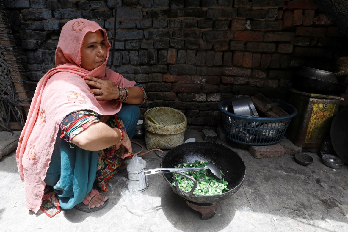 Rubina, 35, prepares food for her family during a heatwave, at home in Jacobabad