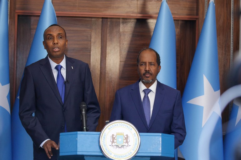 Hamza Abdi Barre, left, received the prime minister's job from President Hassan Sheikh Mohamud, right