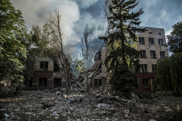 Smoke is seen over the remains of destroyed buildings in eastern Ukraine's Luhansk region