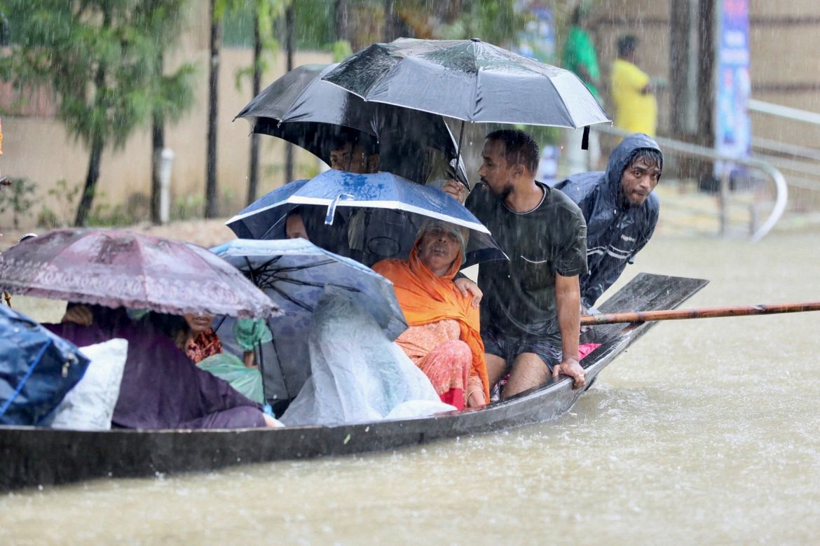 People get on a boat as they look for shelter during a flood