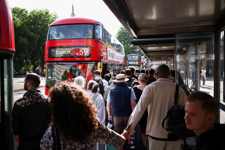Passengers queue for a bus outside Waterloo Station, on the first day of national rail strike in London, UK