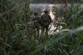 Ukrainian service members are seen on a bank of a river outside the city of Sievierodonetsk, as Russia's attack on Ukraine continues, Ukraine June 19, 2022
