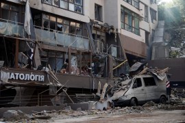 A damaged vehicle is seen outside a building hit by a Russian missile strike in the capital Kyiv on Sunday, June 26, 2022 [Valentyn Ogirenko/Reuters]