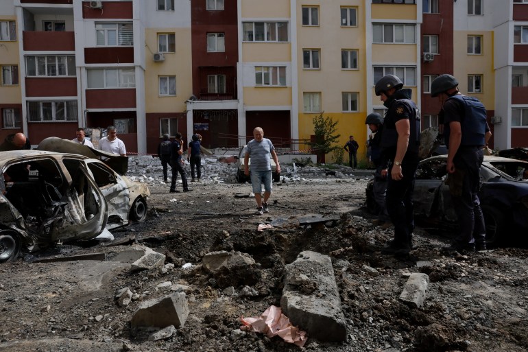 Members of a specialized team that defuses and removes ordnance including bombs, mines and other munitions survey a crater left in the aftermath of overnight shelling as Russia’s attack on Ukraine continues in Kharkiv, Ukraine, June 26, 2022