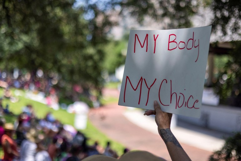 A protester holds a sign reading My body my choice