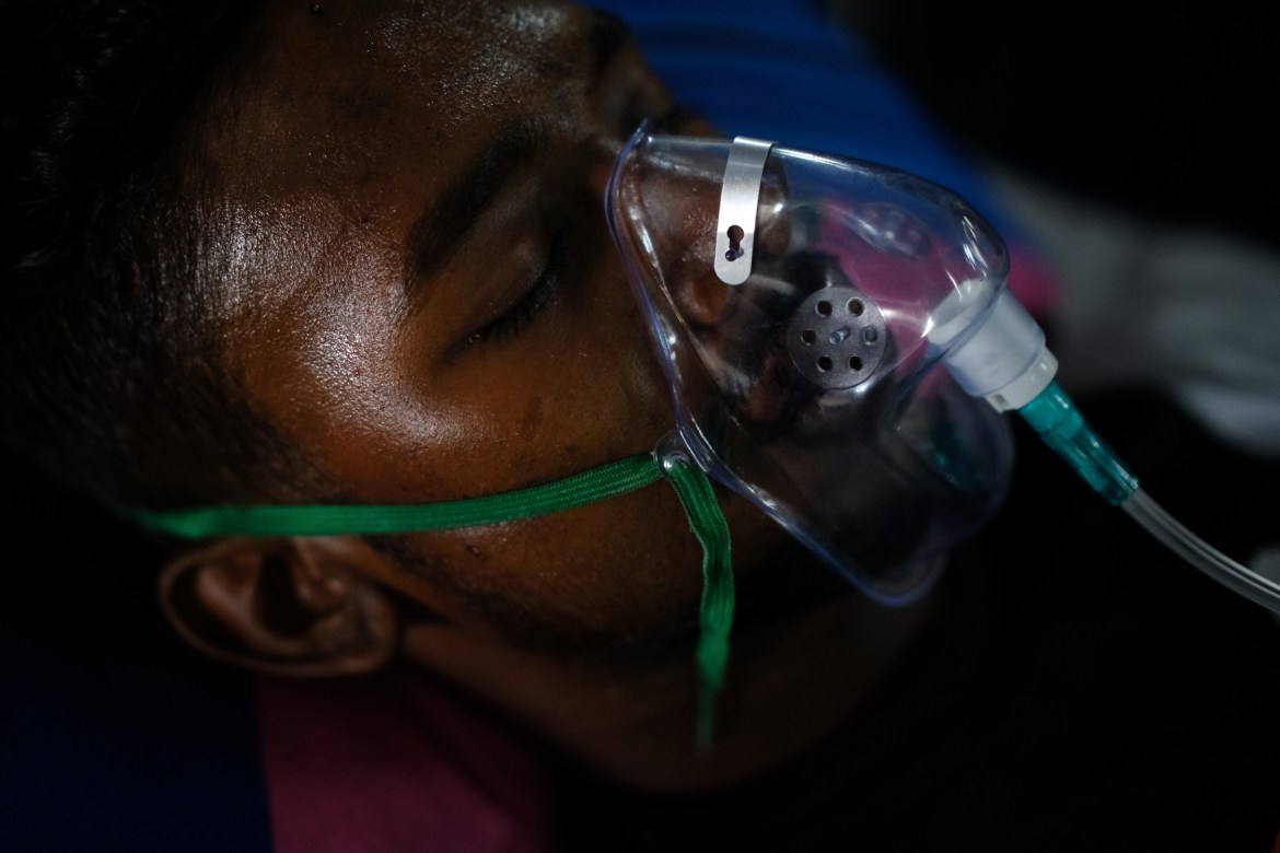 Covered van helper Mohammad Faruk Hossain wearing an oxygen mask