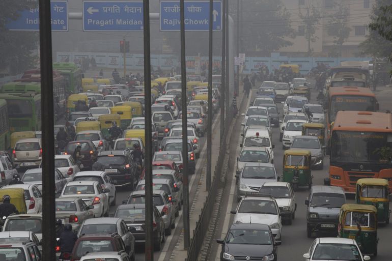 Vehicles sit in traffic on a road shrouded in haze in New Delhi, India