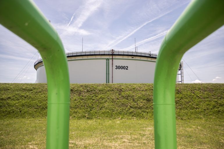 An oil storage tank beyond pipelines at the Duna oil refinery in Hungary