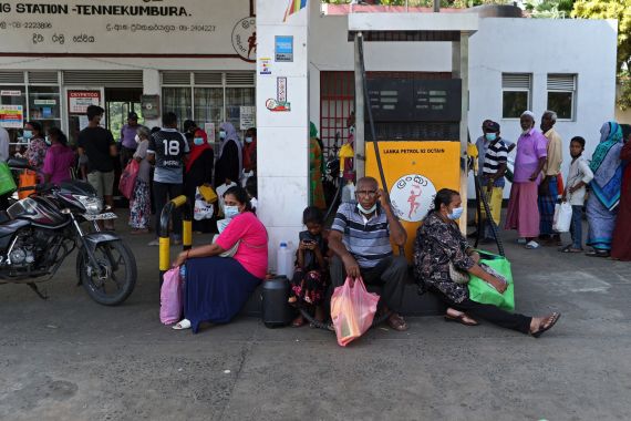 People wait to buy kerosene oil at a gas station in Kandy, Sri Lanka