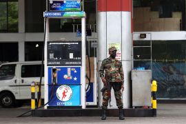 A soldier guards a fuel pump after a gas station ran out of gasoline in Kandy