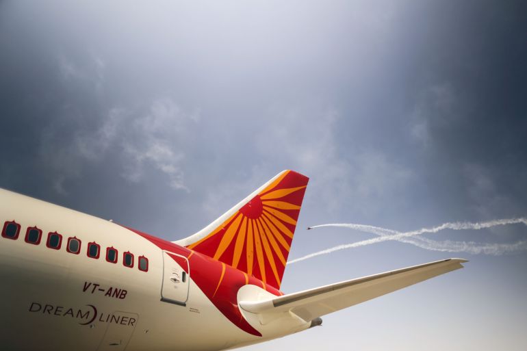 Planes fly past a Boeing Co. 787 Dreamliner aircraft, operated by Air India Ltd., on display in Hyderabad, India