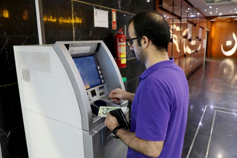 A man uses an ATM in Tehran