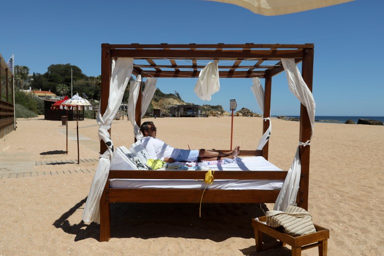 A Swiss tourist enjoys a nearly empty beach in Albufeira, in Portugal's southern Algarve region,