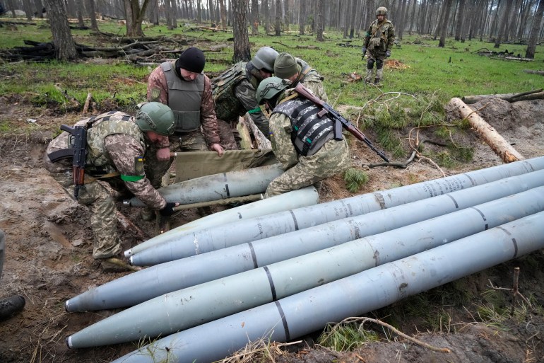 Ukrainian soldiers collect multiple Russian 'Uragan' missiles after fighting in the village of Berezivka, Ukraine in April 2022 [File: Efrem Lukatsky/AP]