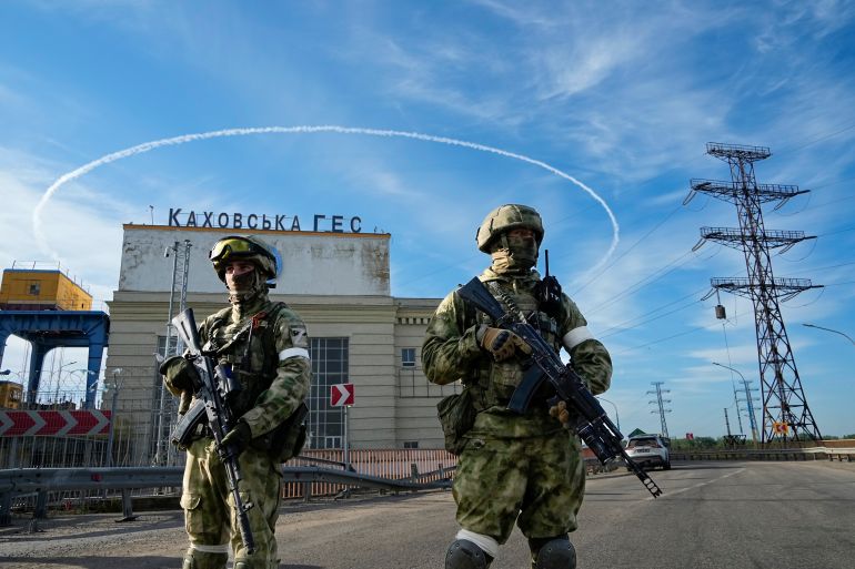 Russian troops guard an entrance of the Kakhovka Hydroelectric Station, a run-of-the-river power plant on the Dnieper River in Kherson region