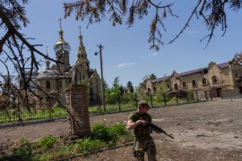A Ukrainian serviceman patrols a village near the frontline in the Donetsk oblast region, eastern Ukraine,