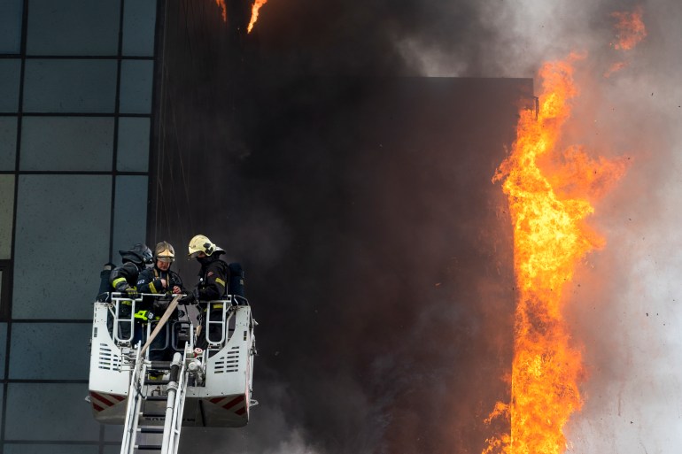 Russian Emergency Situation ministry's firefighters use a lift working at the scene of a business center in Moscow