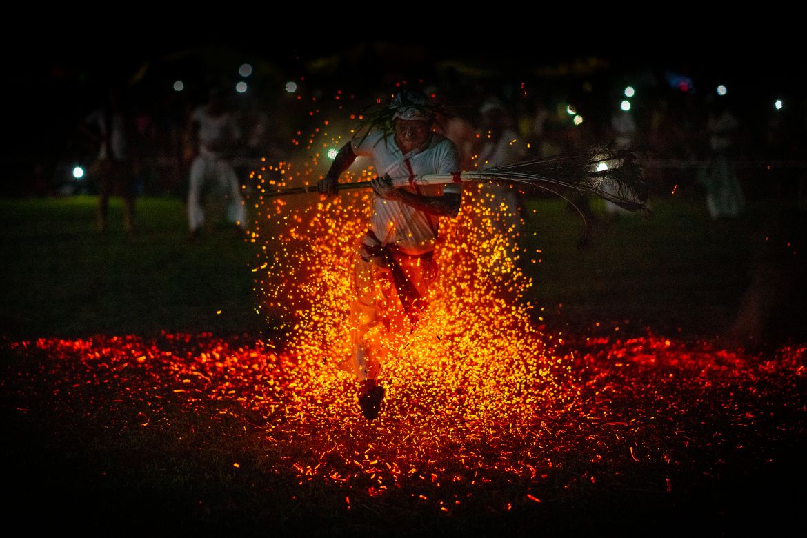 An Indian Rabha tribal Hindu priest runs barefoot over burning charcoal