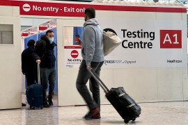 Man with suitcase at COVID testing site at Heathrow airport