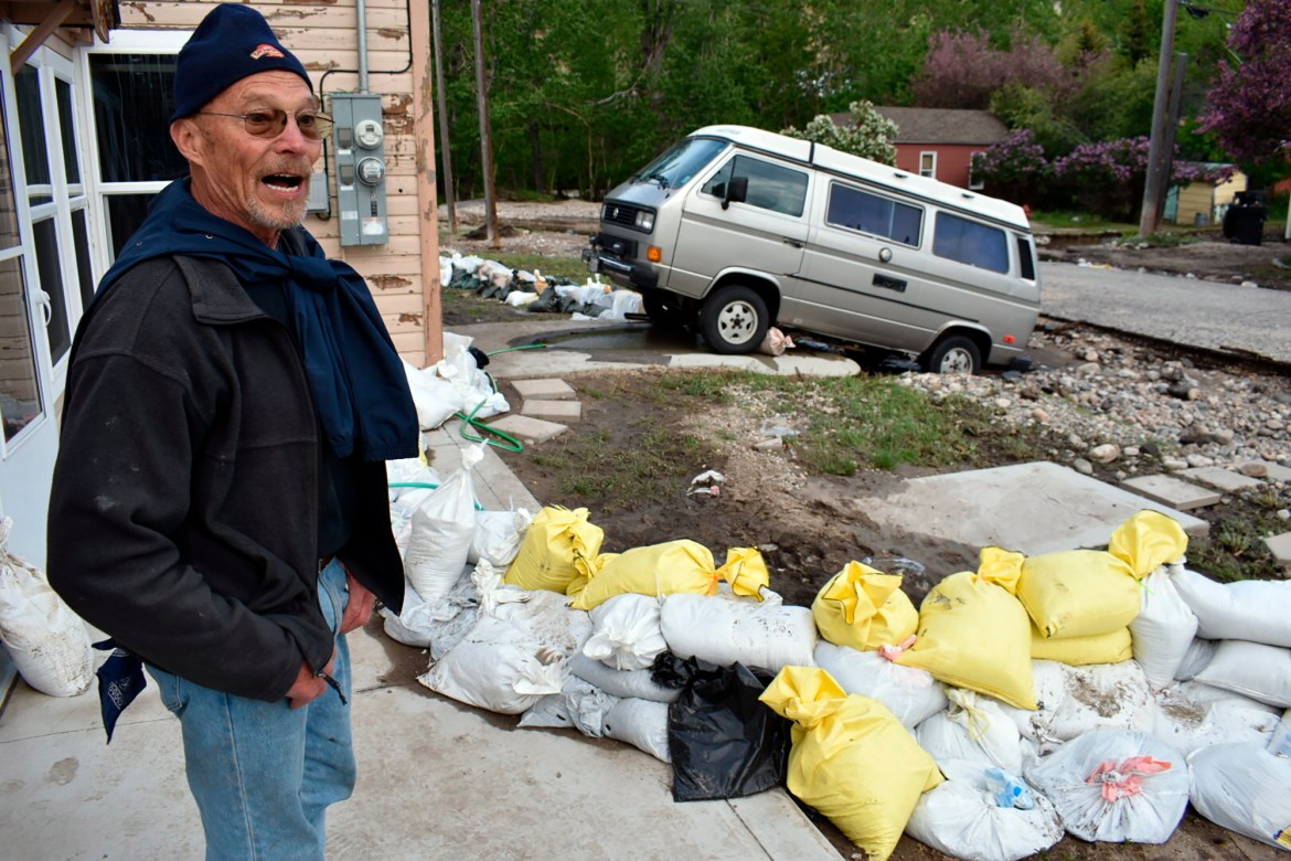 Ken Ebel is seen in front of his flood-damaged house and yard, Tuesday