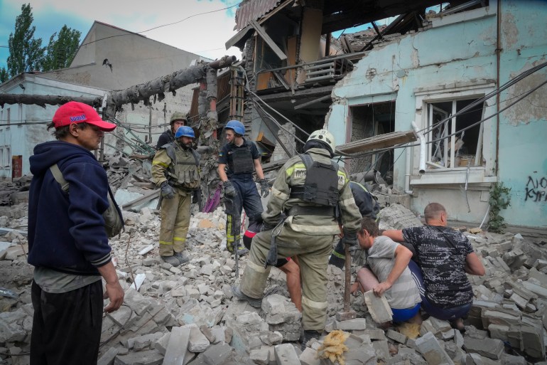 Search and rescue workers and residents remove a body from under the rubble of a building after a Russian air raid in Lysychansk, Luhansk region, Ukraine.