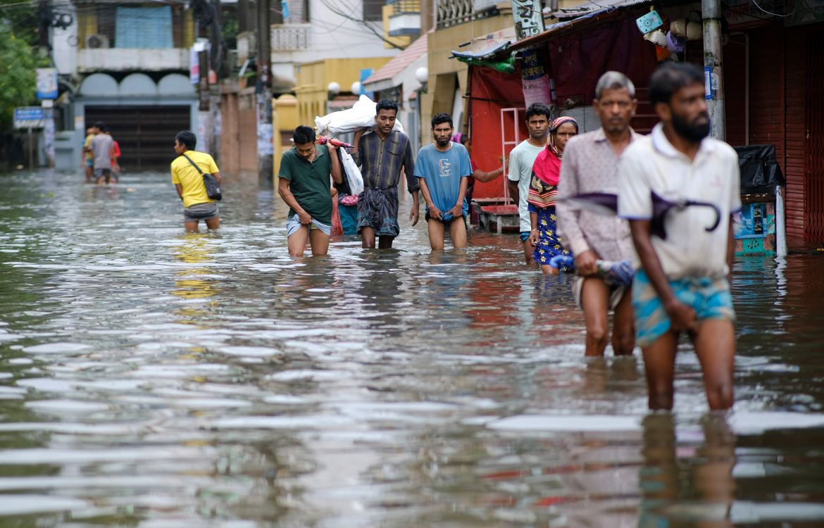 People wade through flood waters in Sylhet