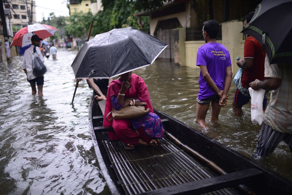 A woman sits in a country boat as it moves through flood waters in Sylhet