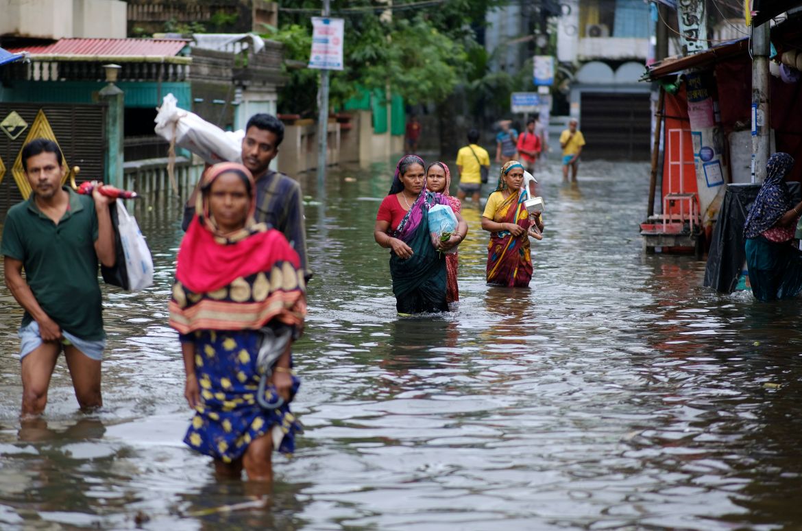 People wade through flood waters in Sylhet