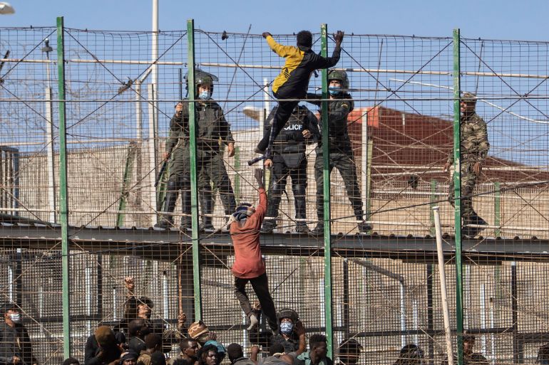 Migrants climb the fences separating the Spanish enclave of Melilla from Morocco