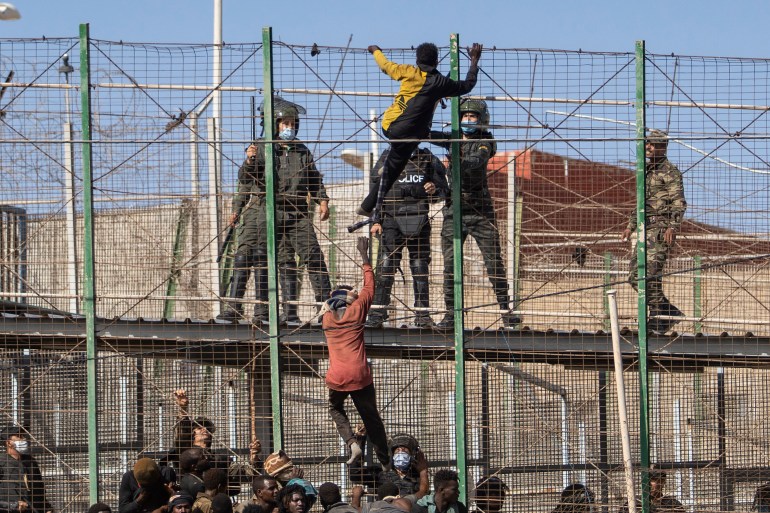Migrants climb the fences separating the Spanish enclave of Melilla from Morocco on June 24, 2022