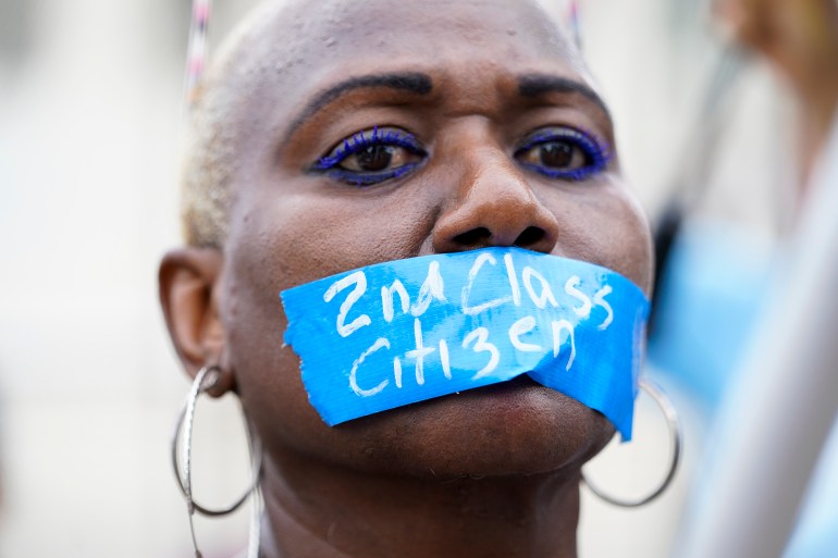 An abortion-rights activist wears tape reading "2nd Class Citizen" on their mouth as they protest outside the Supreme Court in Washington DC, on June 24, 2022 [Jacquelyn Martin/AP]